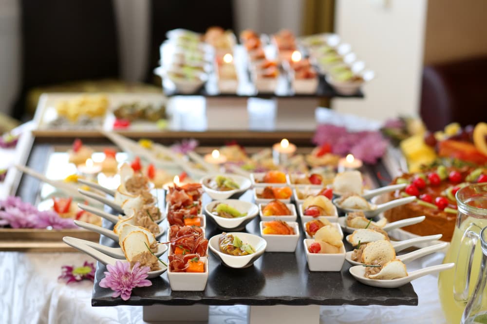 A catered spread of canapés and finger foods on a candlelit table