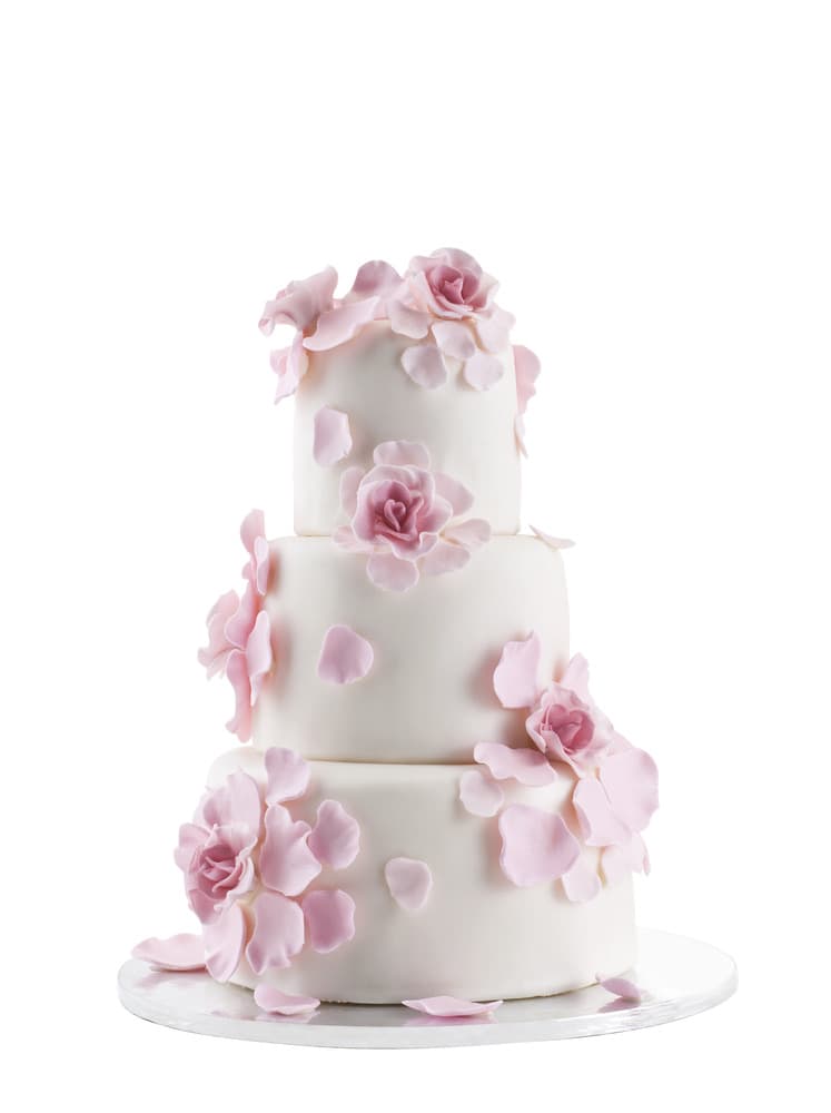 A three-tier white wedding cake trimmed with delicate pink sugar roses