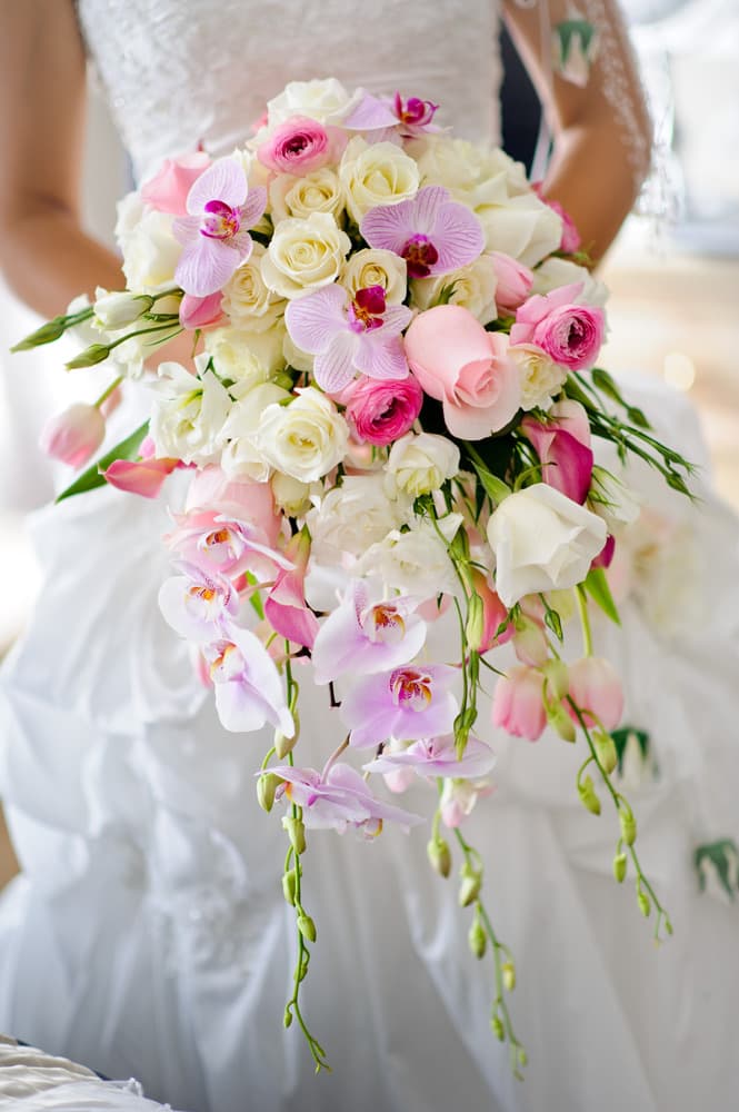 A cascading bridal bouquet of pink roses and orchids